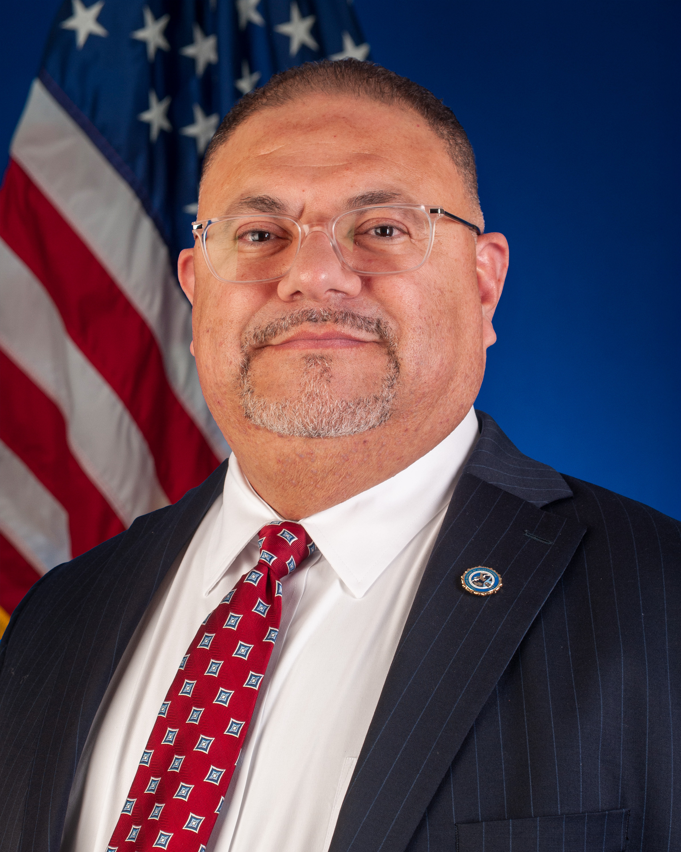 CBI Director Armando Saldate standing in front of US Flag 